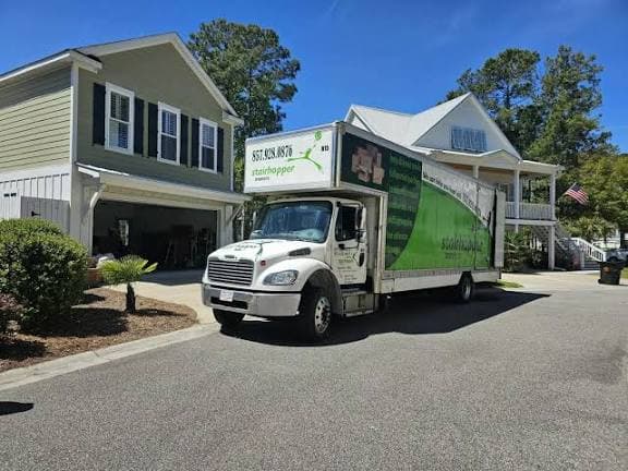 A branded moving truck parked outside a suburban home